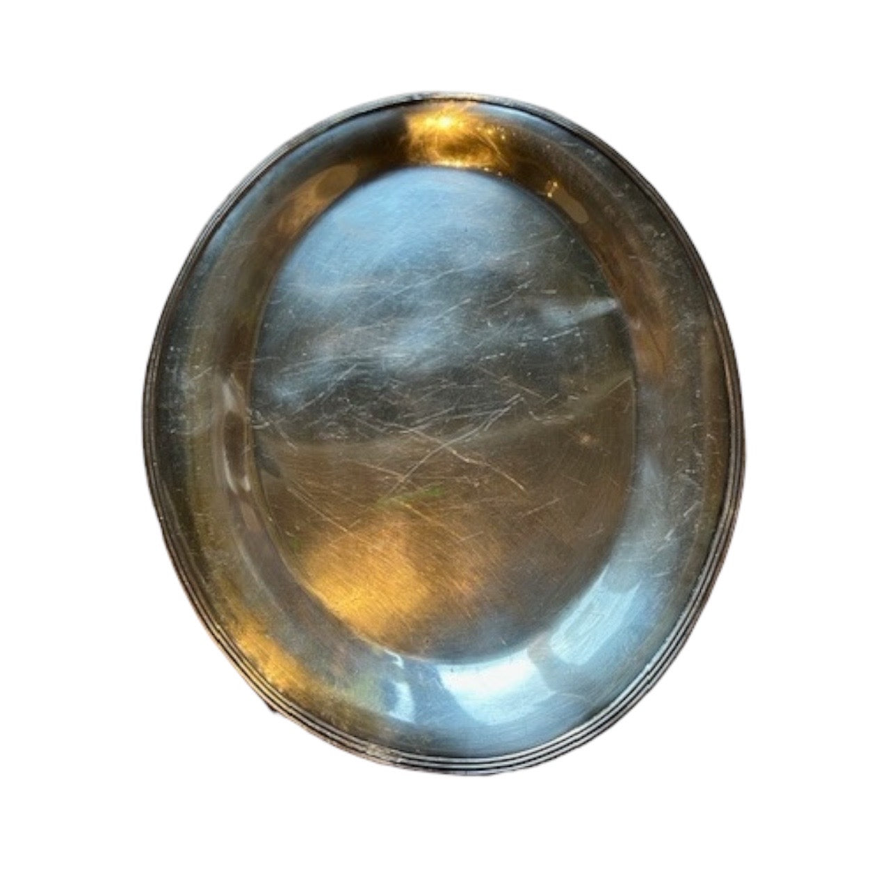 Top-down view of the oval silver-plate tray showing the scratched polished well.