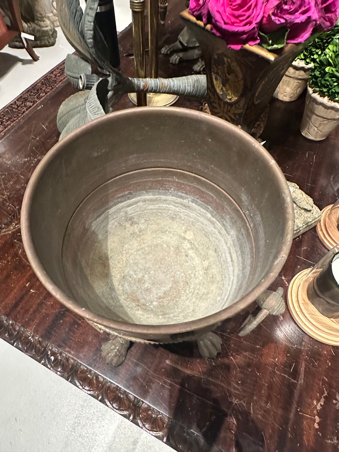Top-down view into the empty bronze jardiniere bowl showing weathered interior
