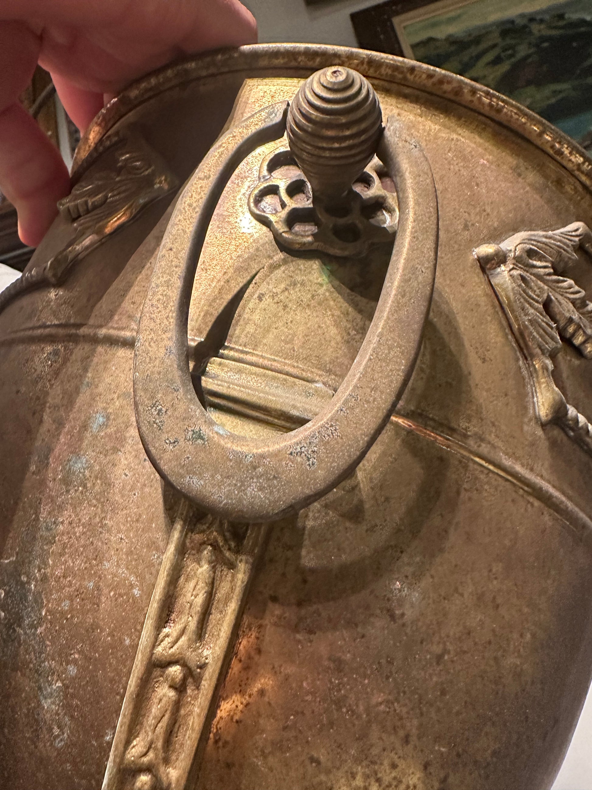 Close-up of bronze jardiniere's oval ring handle, beehive finial and beaded rim