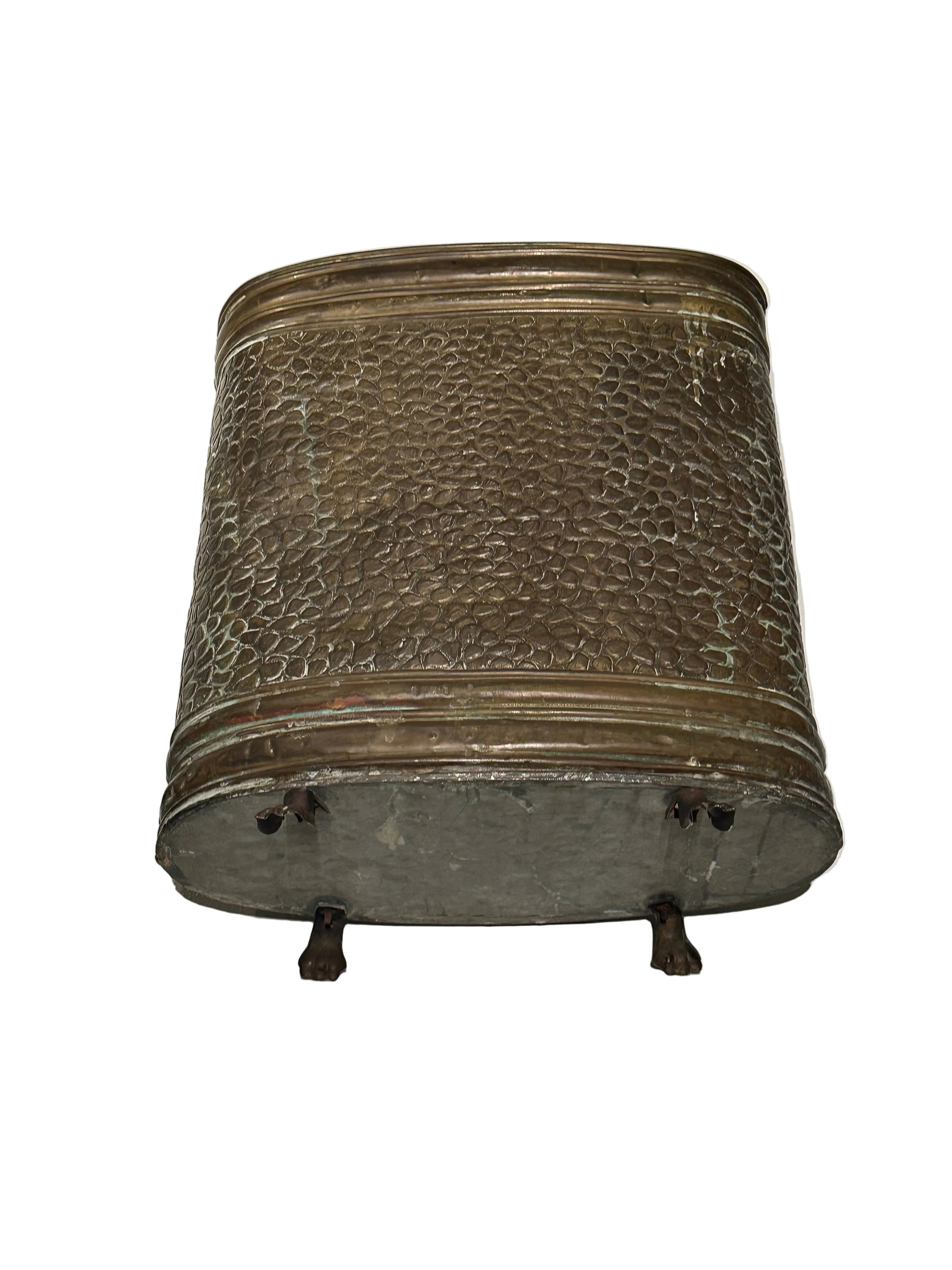 Side of brass oval umbrella stand showing hammered texture and paw feet
