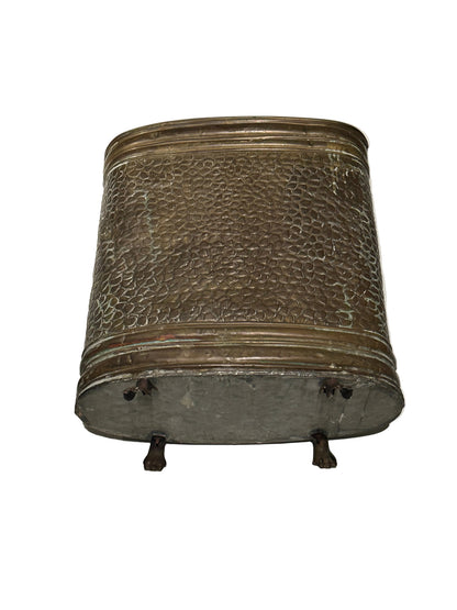 Side of brass oval umbrella stand showing hammered texture and paw feet