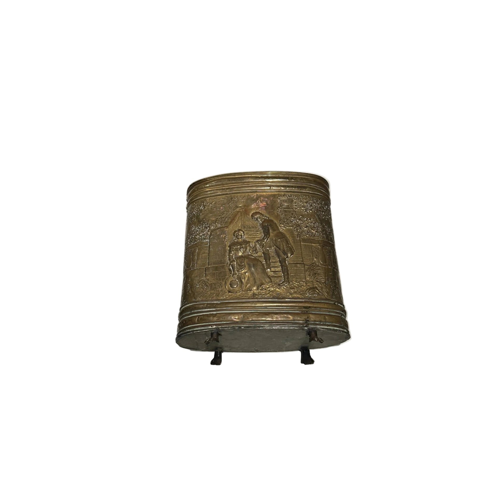 Front view of oval brass umbrella stand with repousse figural courting scene