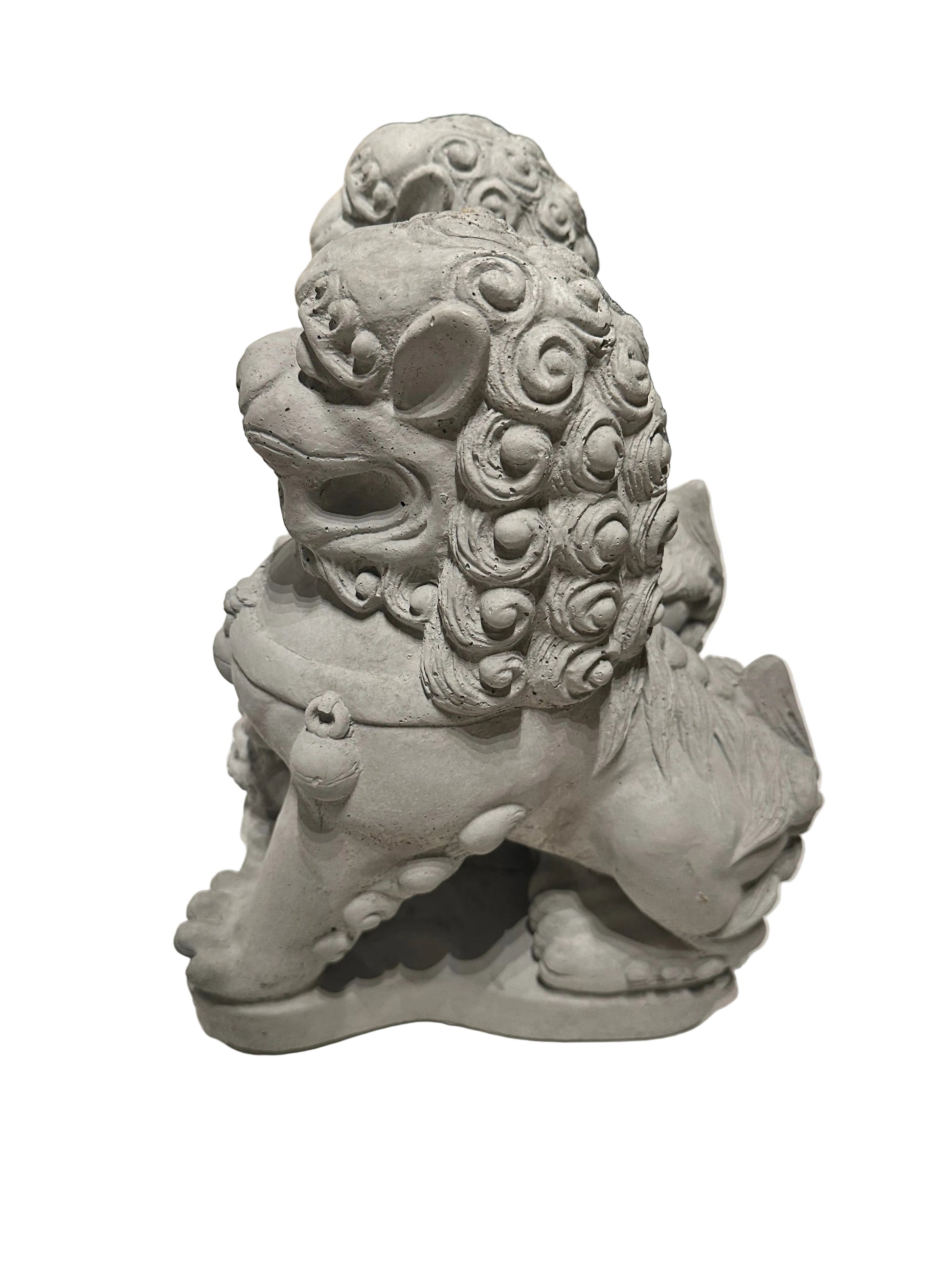 Side view of a cast concrete Foo dog showing curled mane and seated pose