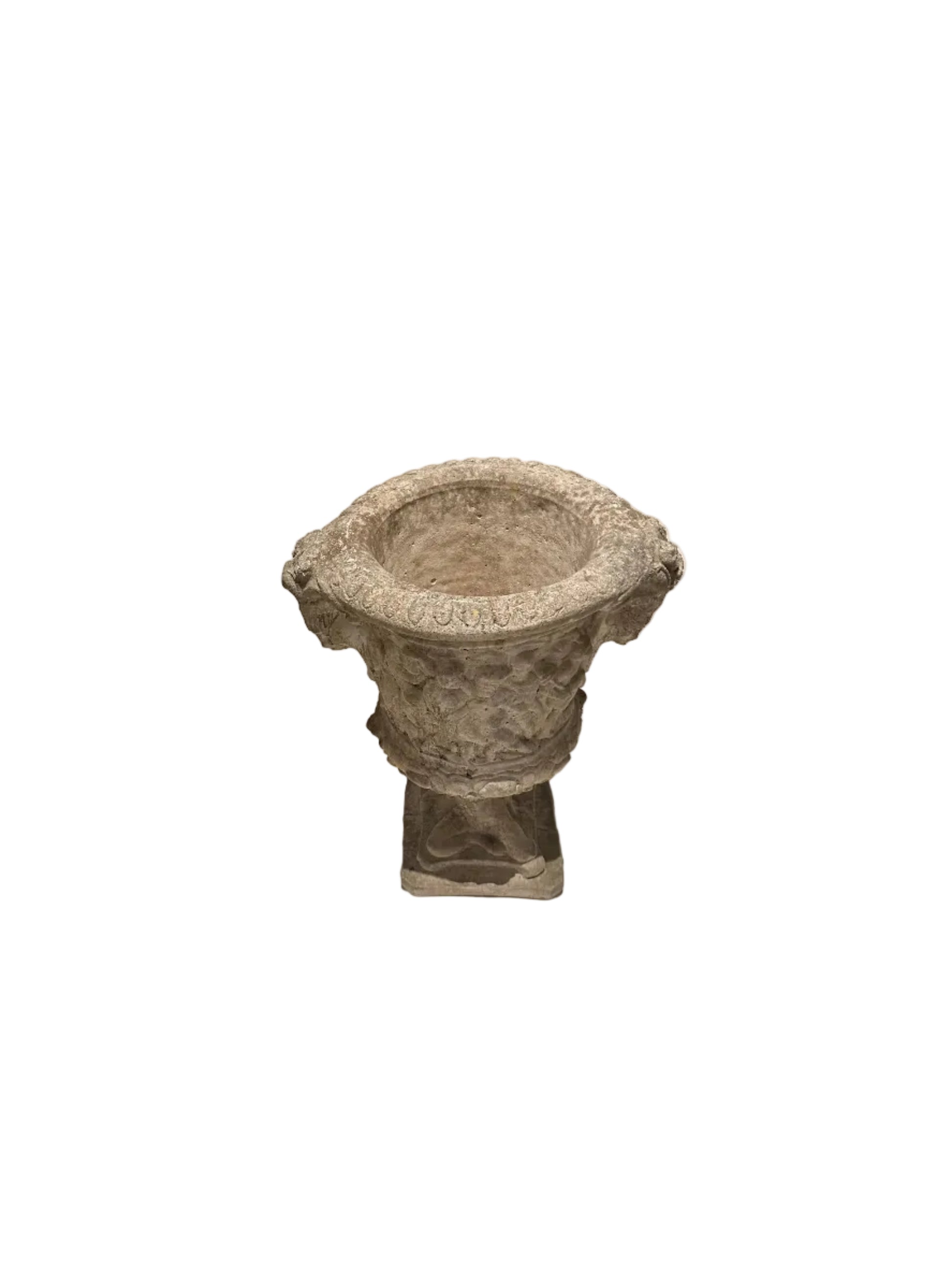 Three-quarter view of weathered concrete Regency urn on pedestal