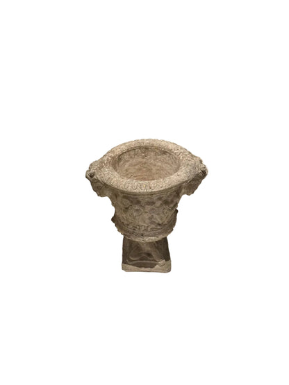 Three-quarter view of weathered concrete Regency urn on pedestal
