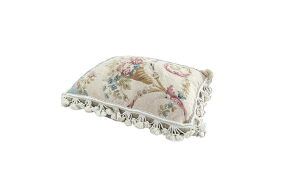 Angled top view of floral trumpet basket needlepoint pillow with tassel fringe