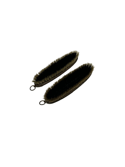 Pair of clothes-care brushes removed from cabinet, dark bristles facing up on white.