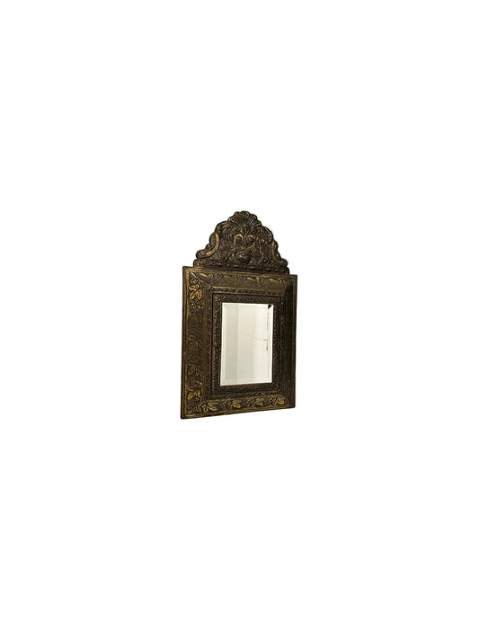 Antique 1930s brass wall cabinet open, showing two embossed clothes-care brushes inside.