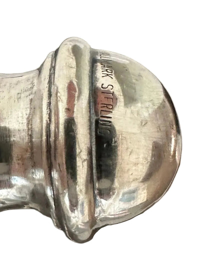 Close-up of fluted sterling handle end stamped 'Hallmark Sterling'.