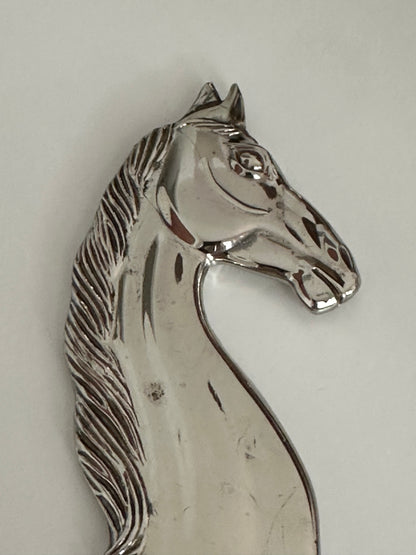 Close-up of the polished horse head on the vintage silver plate bottle opener.
