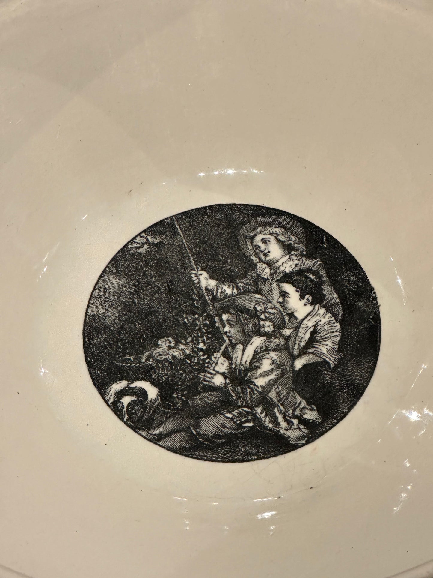 Close-up of the black transfer scene of figures fishing in the center of the bowl