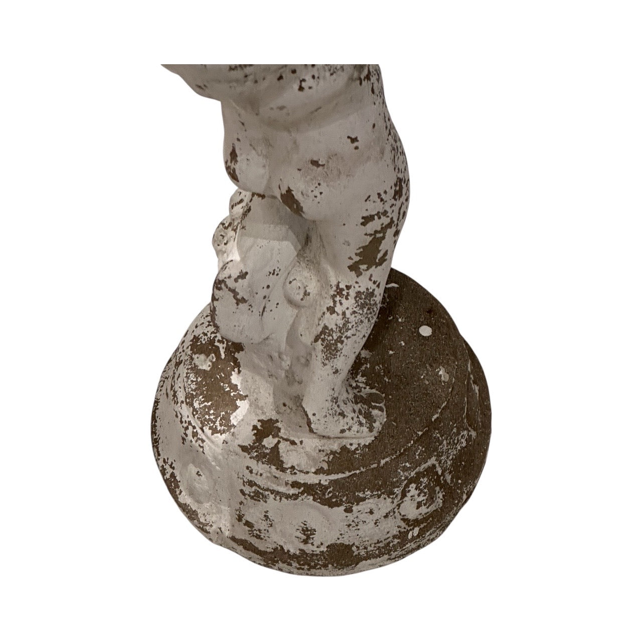 Close-up of the concrete figure's legs and round base with worn white paint