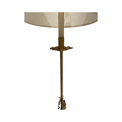 Lower portion of the gilt floor lamp showing slim stem and leaf-form finial beneath the shade
