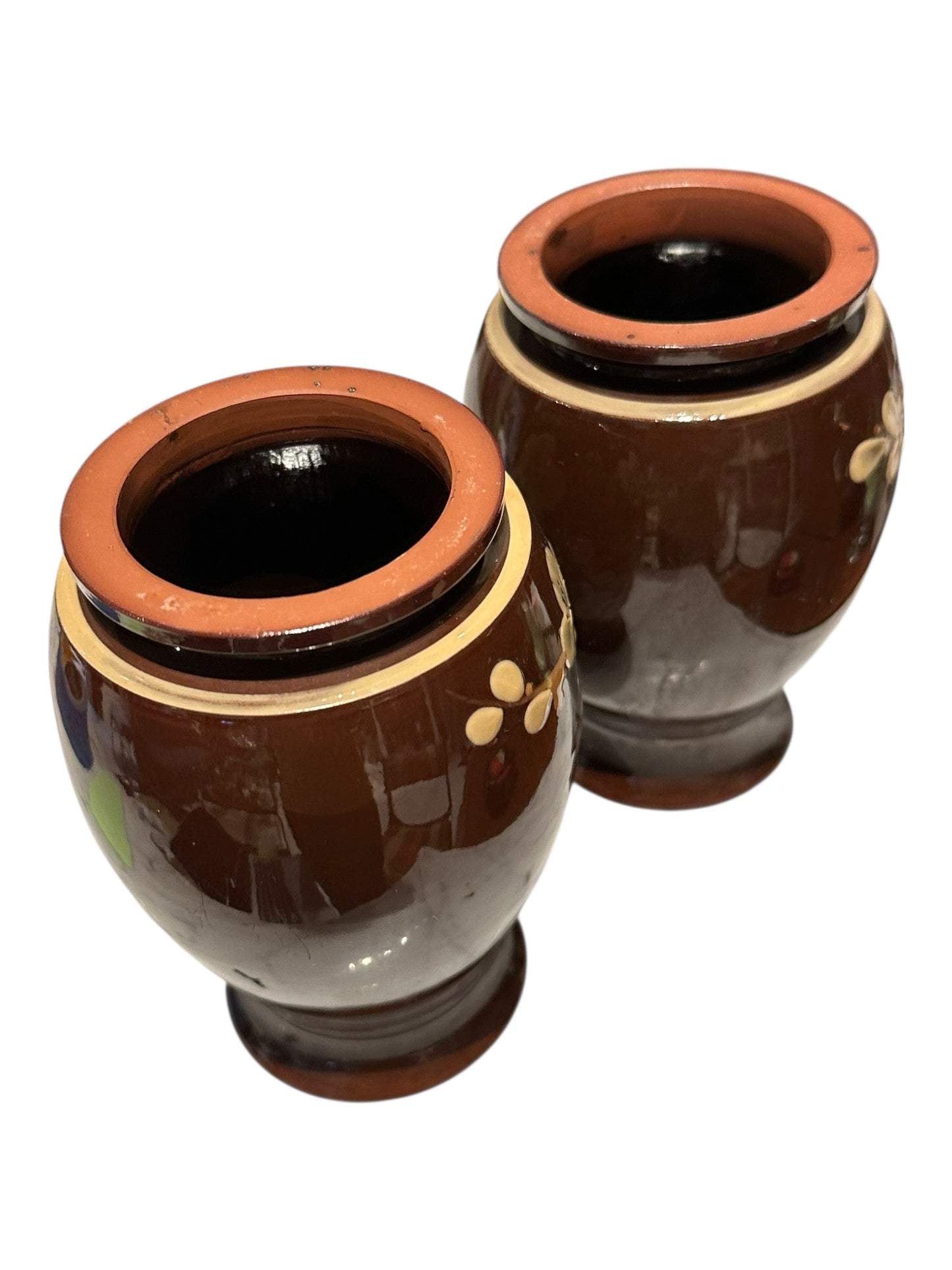 Pair of brown-glazed floral vases viewed from above showing terracotta rims and open mouths