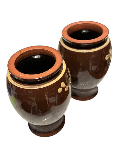 Pair of brown-glazed floral vases viewed from above showing terracotta rims and open mouths