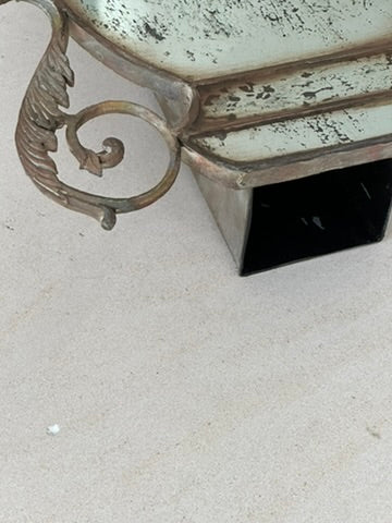 Detail of the mirrored urn vase base corner and scrolled handle on tile