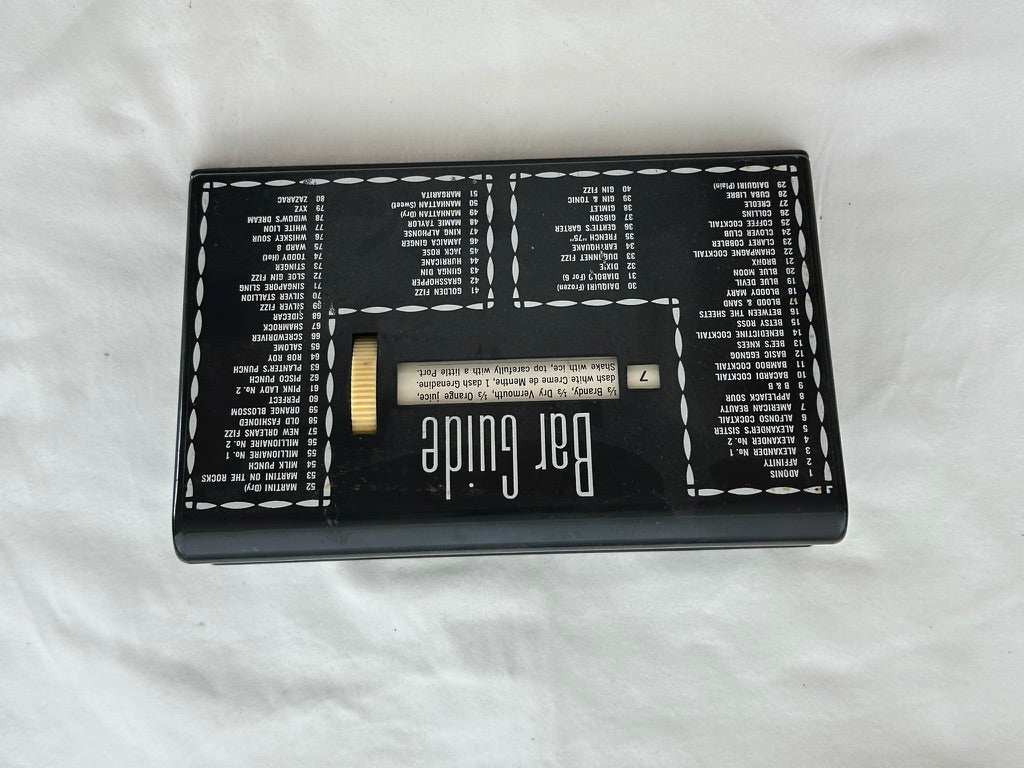 MCM Bar Guide viewed from above upside down on white cloth, full cocktail index visible