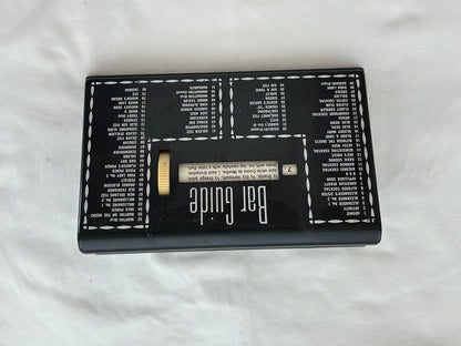MCM Bar Guide viewed from above upside down on white cloth, full cocktail index visible