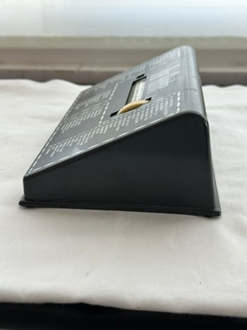 MCM Bar Guide angled side view on white cloth, ivory scroll wheel and cocktail index visible