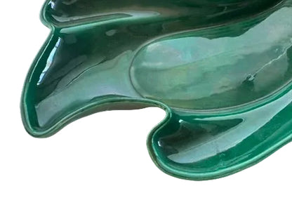 Close-up of the glossy green glazed sculpted leaf edge and curled tip of the Claire Lerner bowl