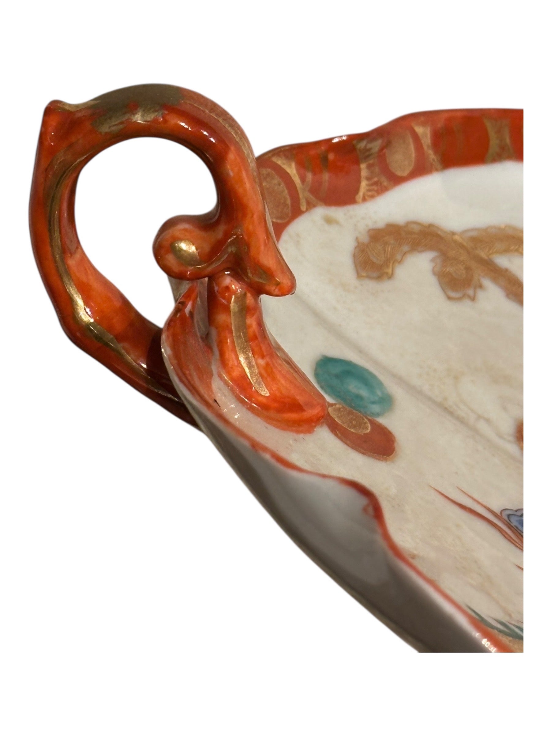 Japanese Kutani porcelain dish, close-up of orange-red and gilt scrolled loop handle