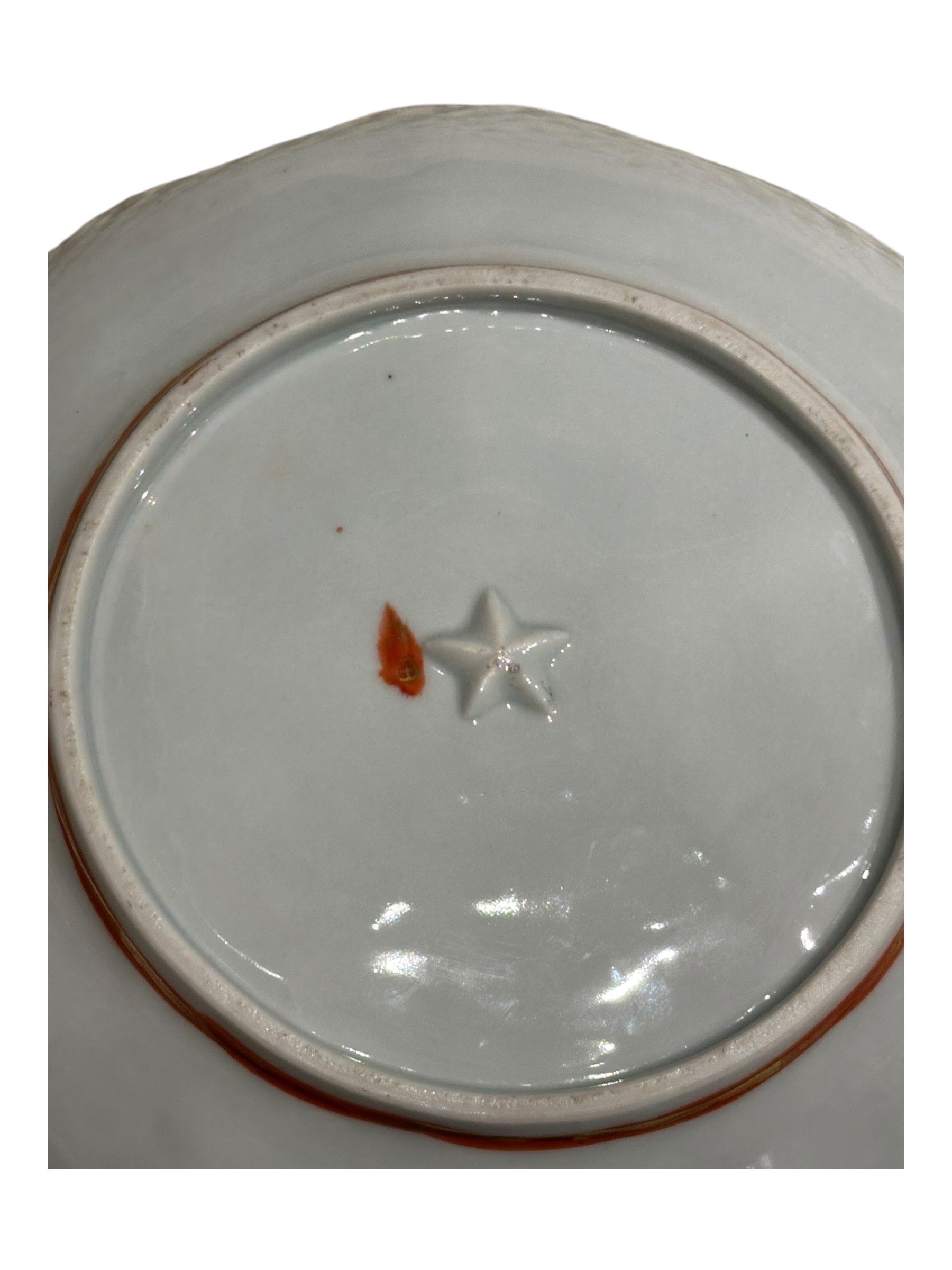 Japanese Kutani porcelain dish, close-up of molded star mark on white glazed underside