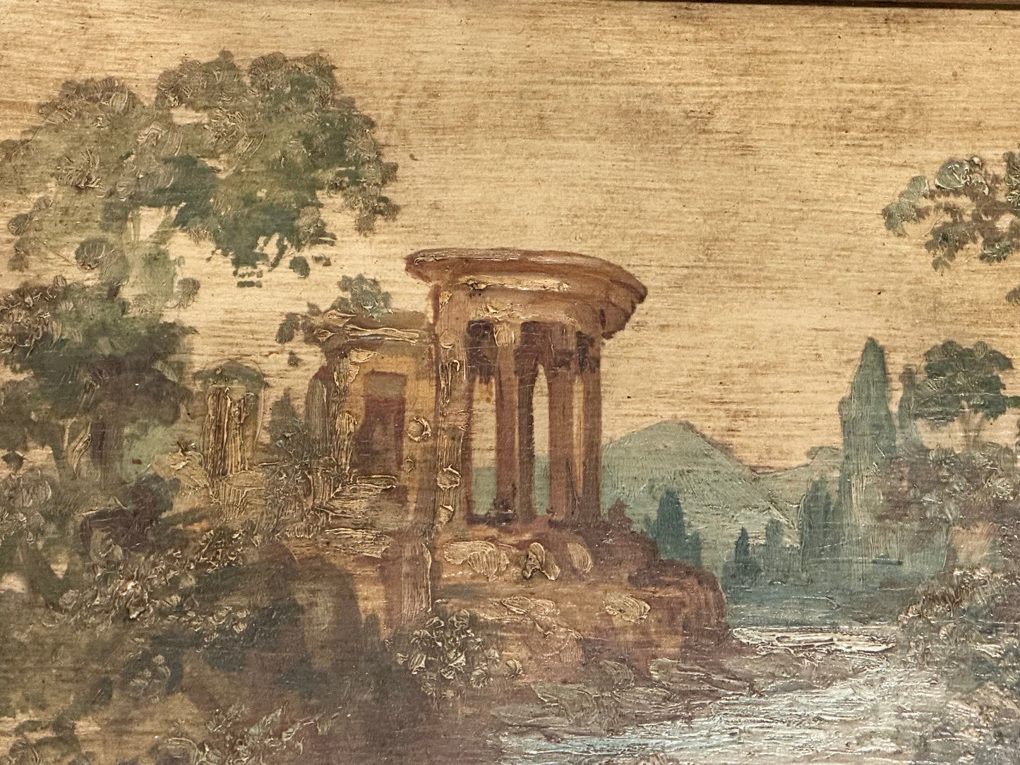 Close-up of hand-painted tabletop scene: a domed classical temple ruin beside a river and mountains.