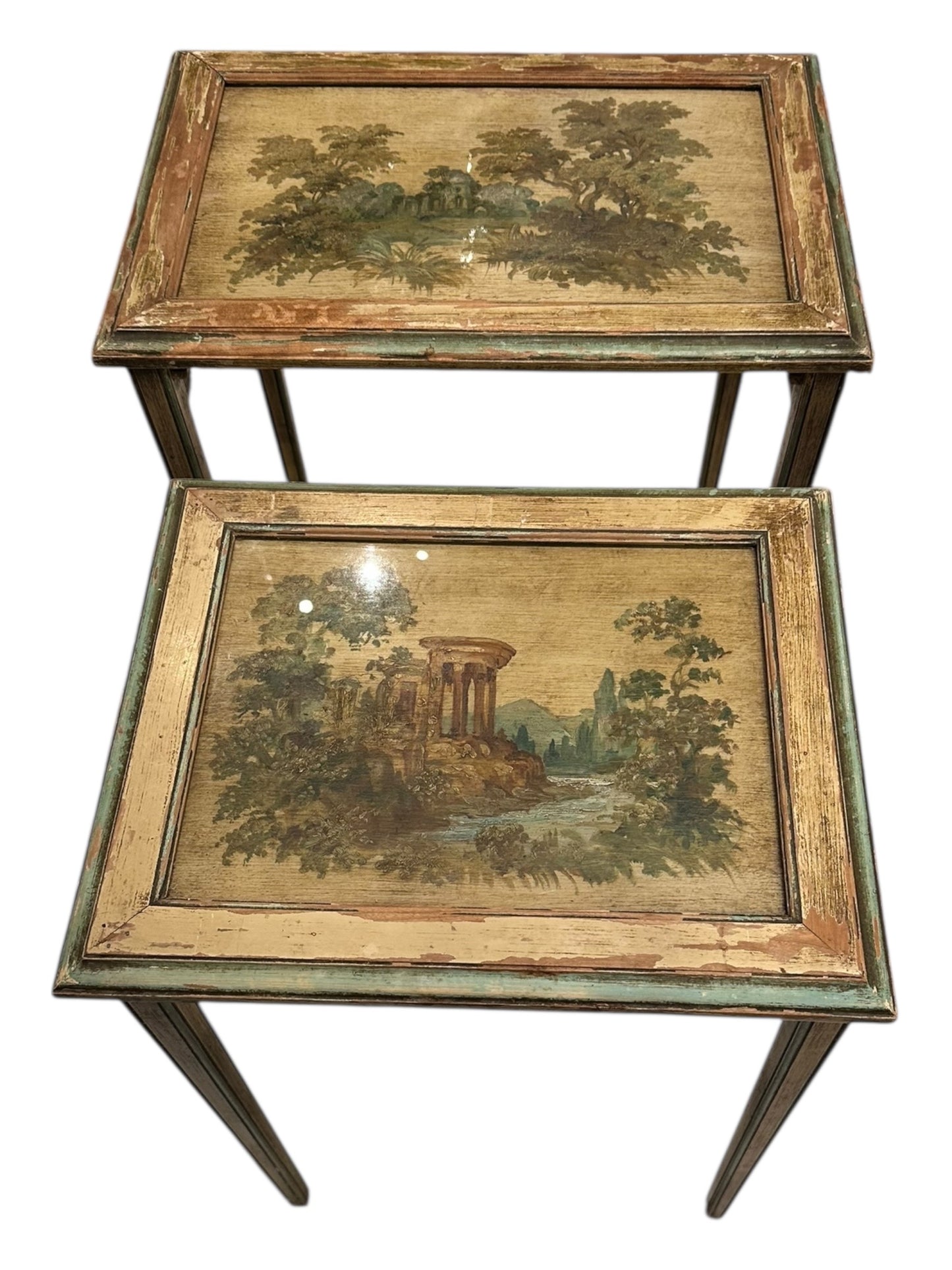 Two stacked nesting tables with hand-painted landscape tops under glass.