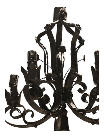 Black wrought iron petite chandelier, close-up of scrolled arms and bulb sockets