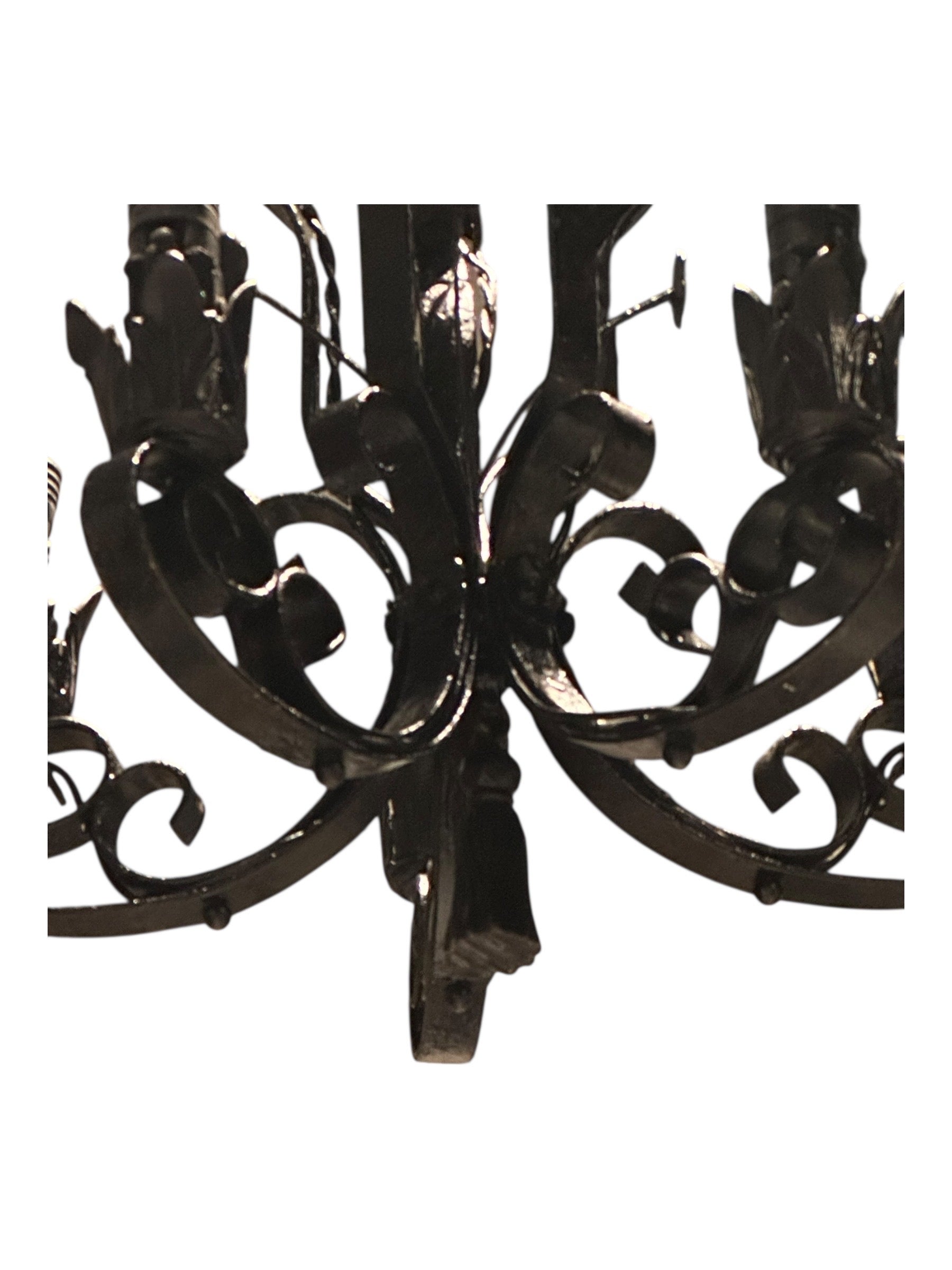 Bottom view of black wrought iron petite chandelier scrollwork and arms