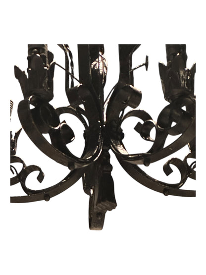 Bottom view of black wrought iron petite chandelier scrollwork and arms