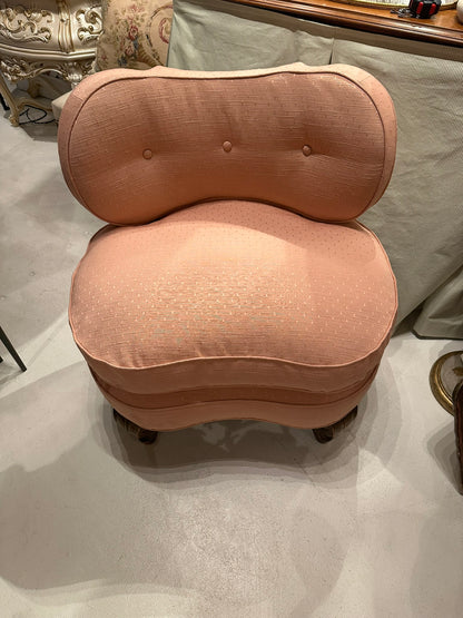 Antique pink coral boudoir chair, front view of tufted back and rounded seat in showroom