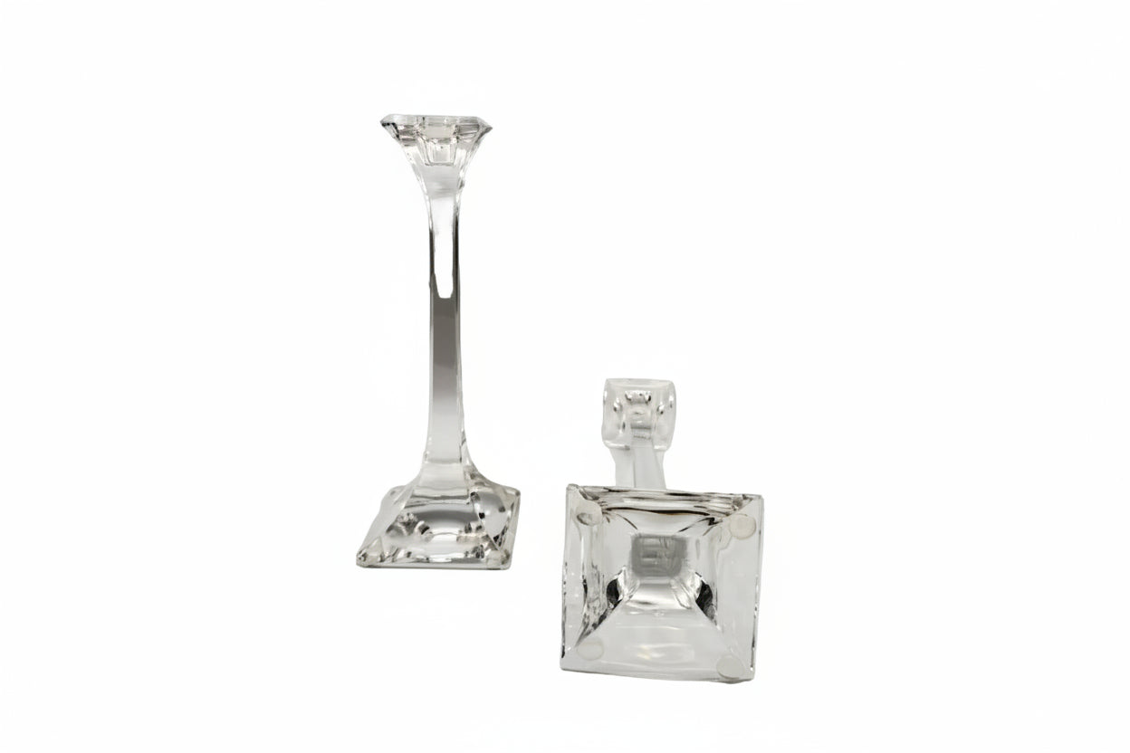 Tiffany & Co. crystal candlestick upright beside a second laid down to show the square base