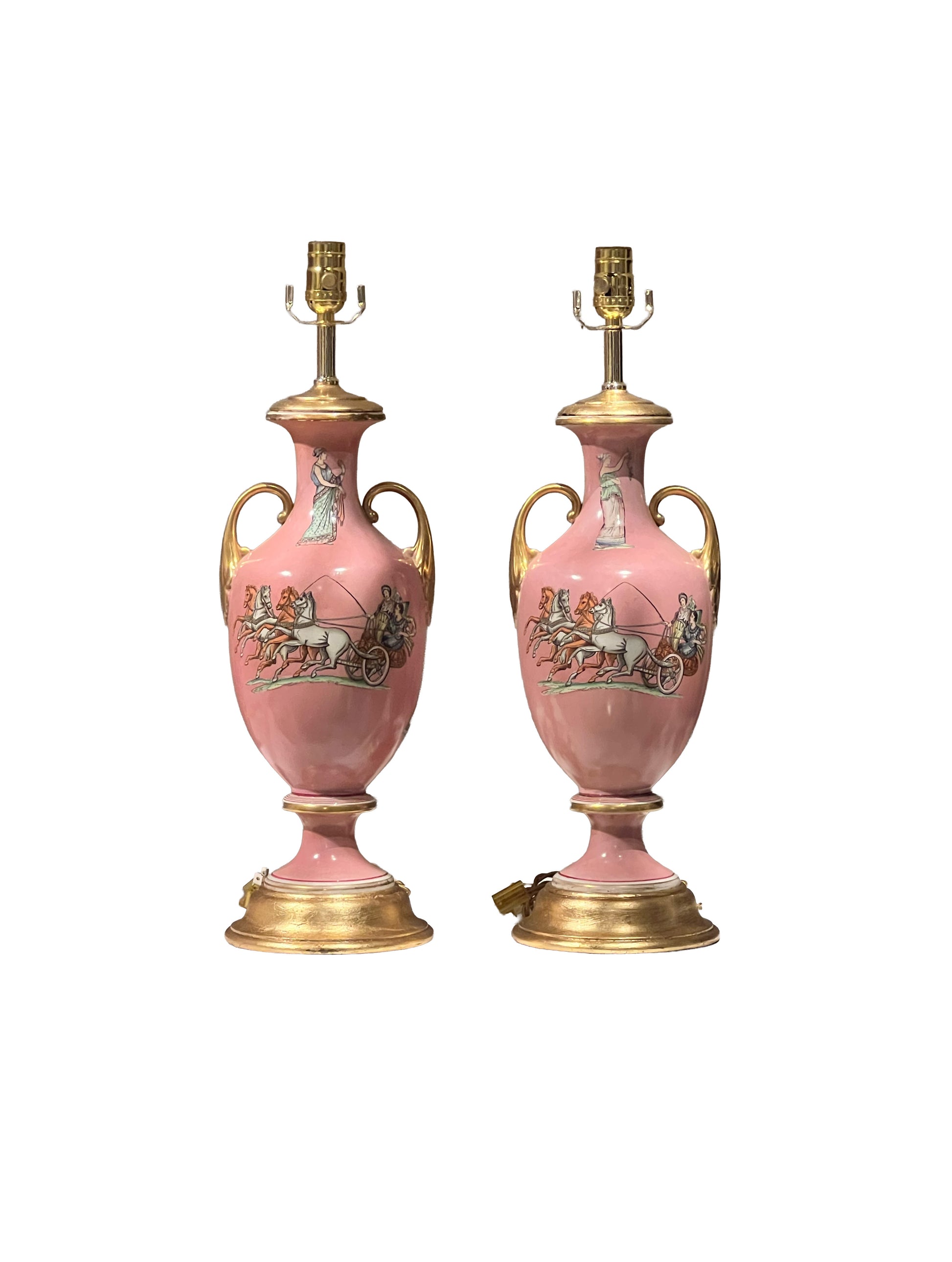 Pair of pink neoclassical urn lamps with gold handles and chariot scenes on a white background