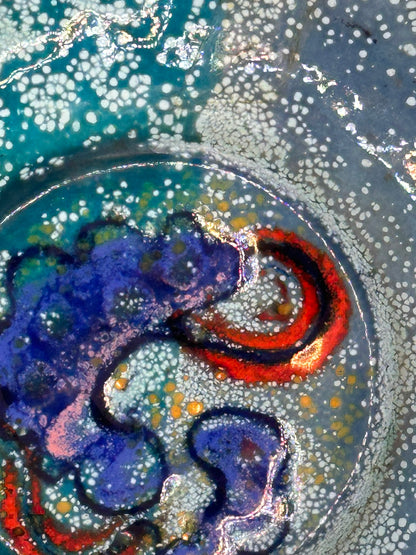 Close-up of Doris Hall dish center, cobalt-blue swirl and red arc detail in speckled enamel glaze