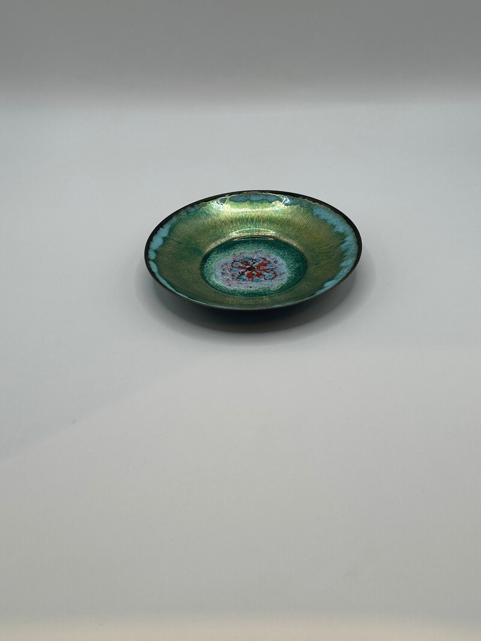 Doris Hall petite green enamel dish, angled profile showing teal rim and red floral center