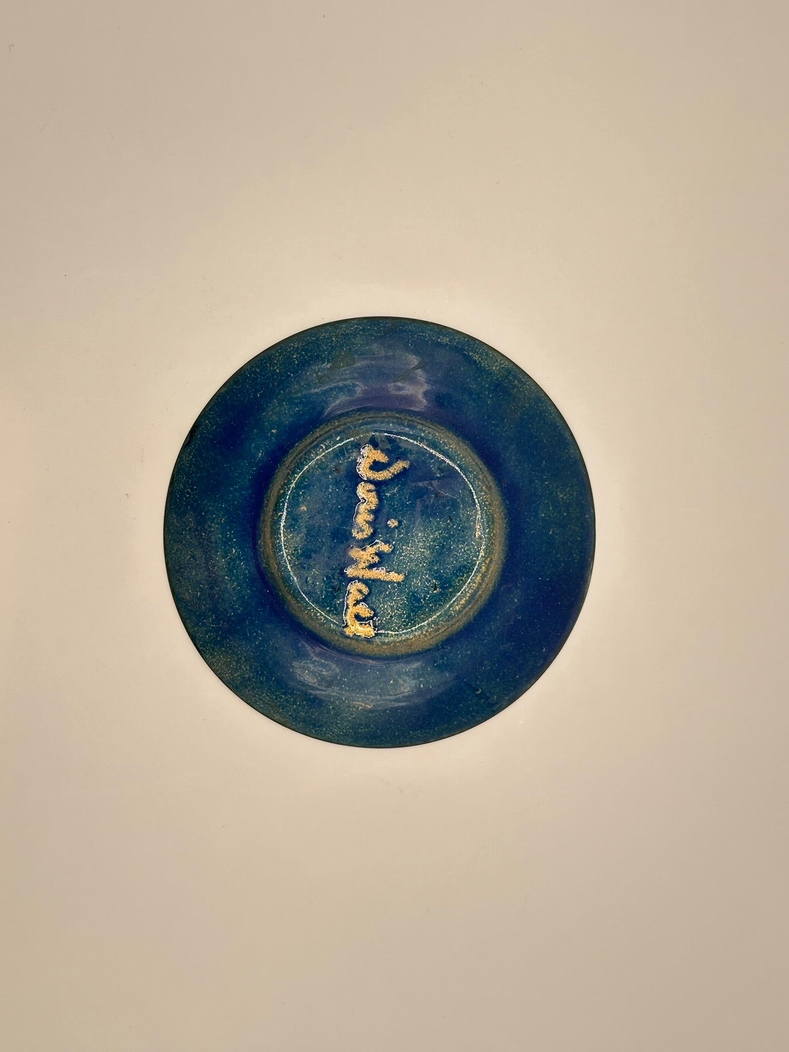 Underside of Doris Hall turquoise enamel dish, signed 'Doris Hall' in gold cursive script