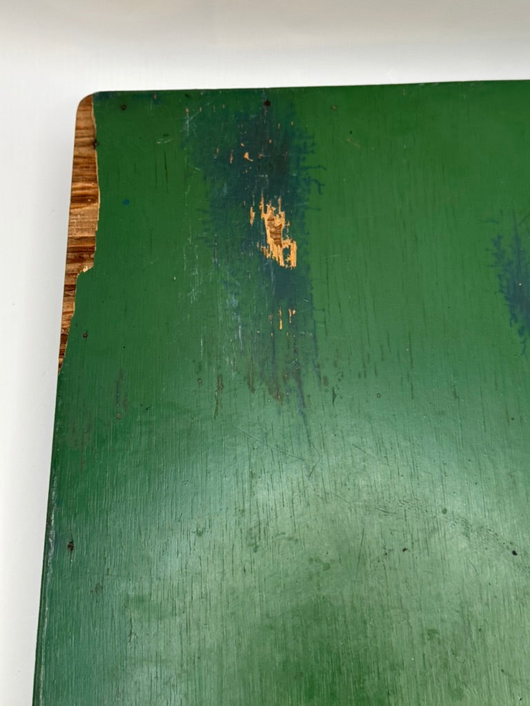 Underside of green wood tray showing worn green paint, scratches and exposed wood