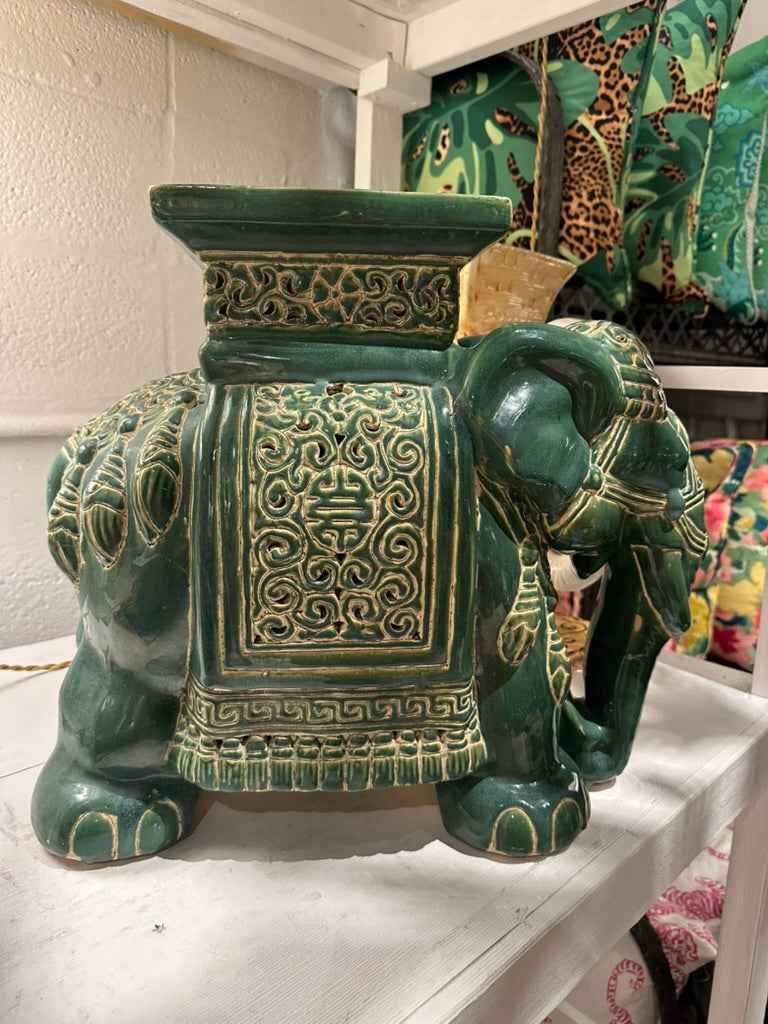 Green ceramic elephant garden stool with embossed scrollwork blanket, shown in a room setting
