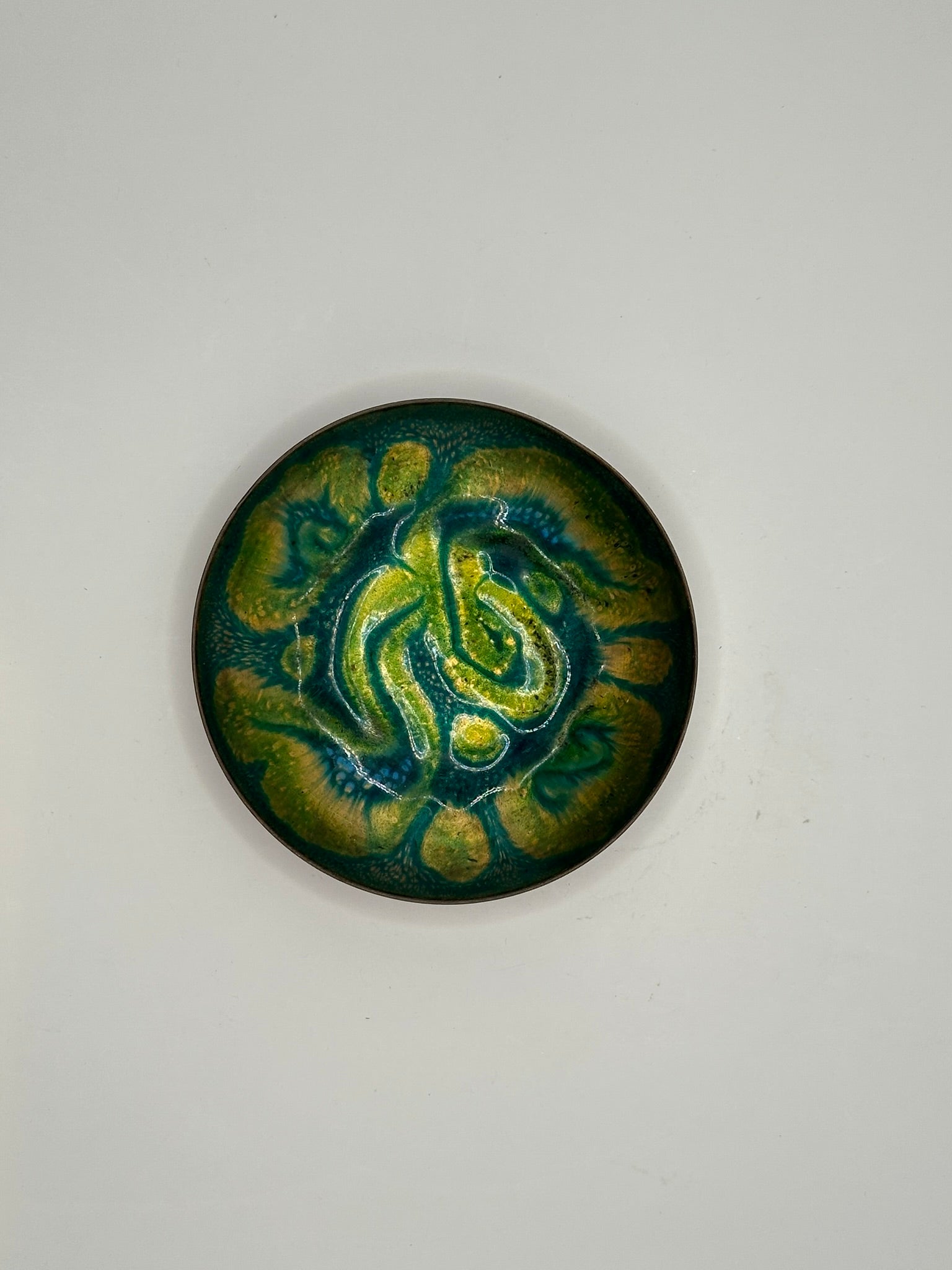 Doris Hall small enamel-on-copper dish, top view of green, yellow and teal abstract swirl glaze