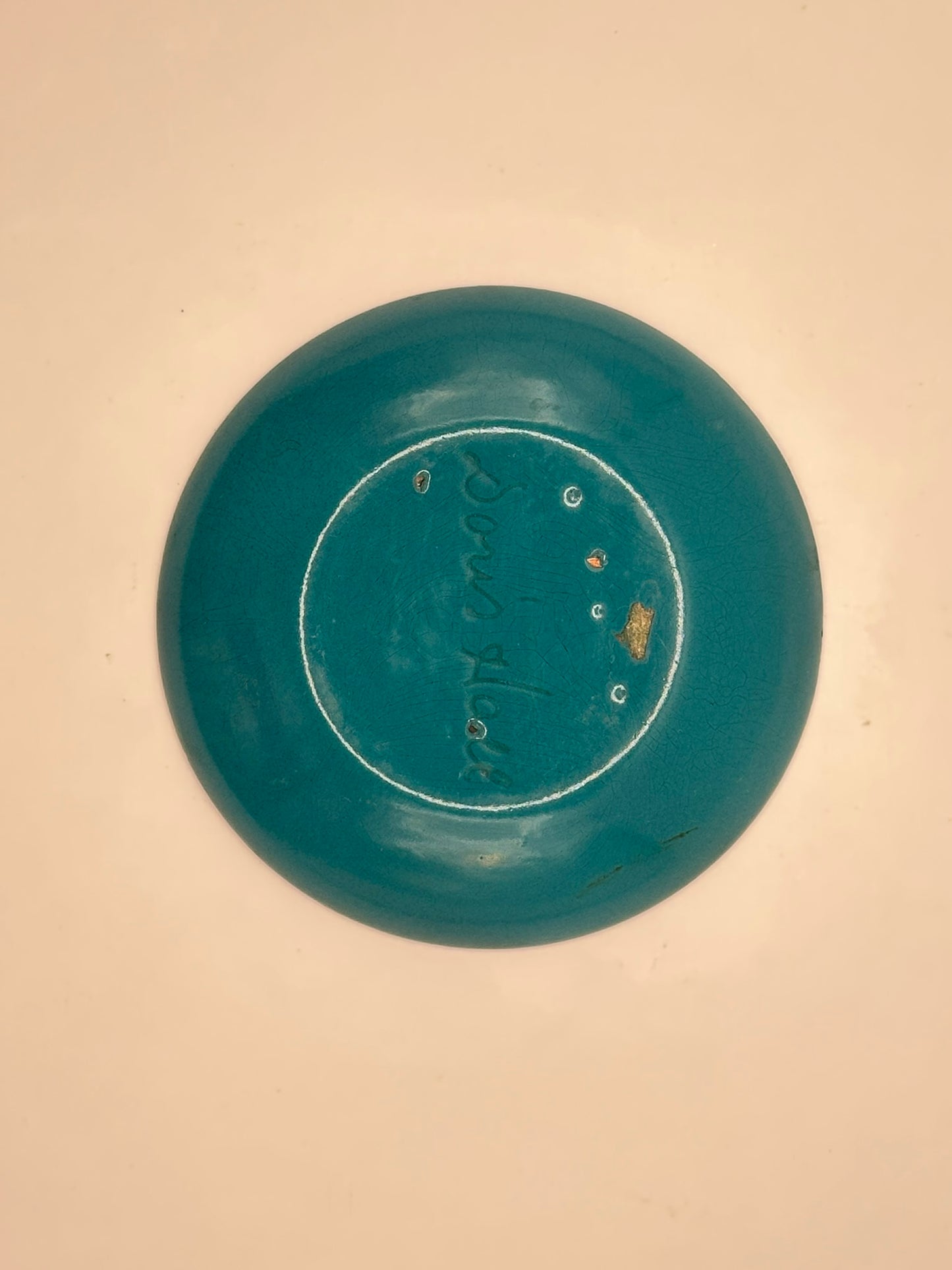 Close-up of Doris Hall enamel dish underside, teal enamel with engraved 'Doris Hall' mark
