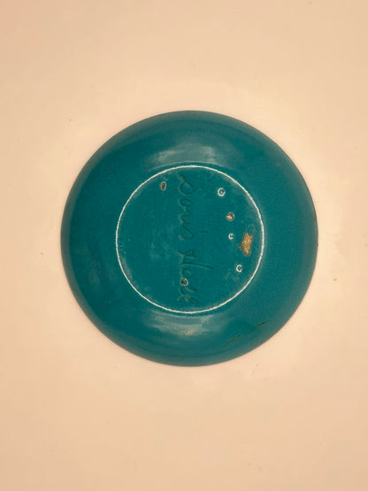 Close-up of Doris Hall enamel dish underside, teal enamel with engraved 'Doris Hall' mark