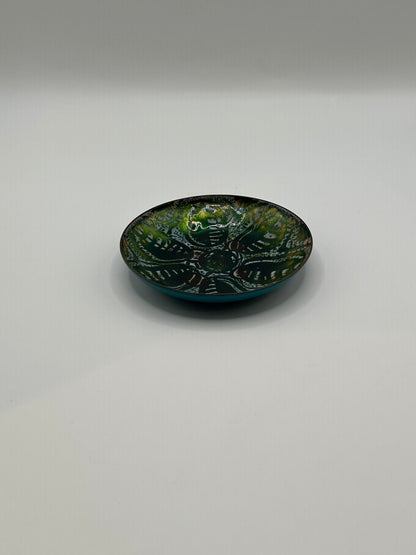 Side-angle view of shallow Doris Hall enamel dish, green interior and turquoise base