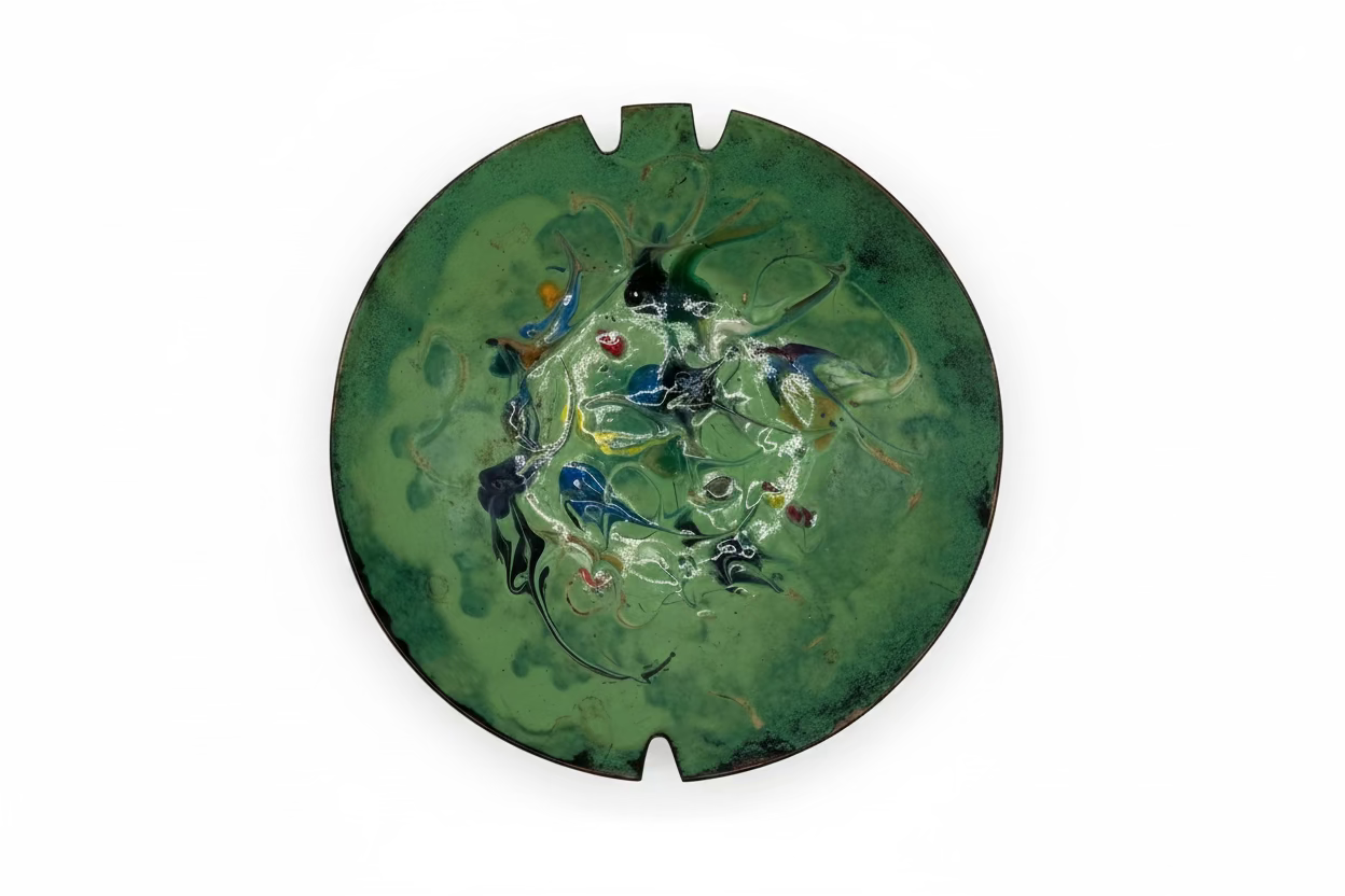 Vintage MCM enamel-over-copper ashtray, top view, green with multicolor abstract swirls and two cigarette rests