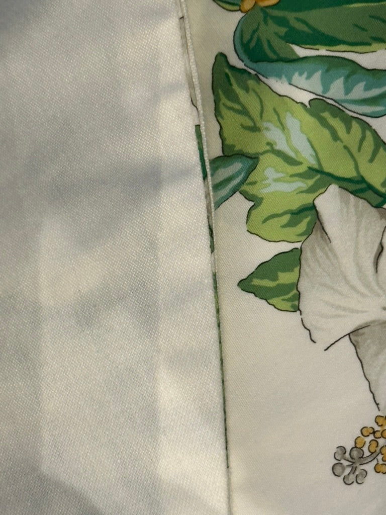 Brunschwig & Fils Anima tablecloth edge detail with white hibiscus and green leaves along the hem