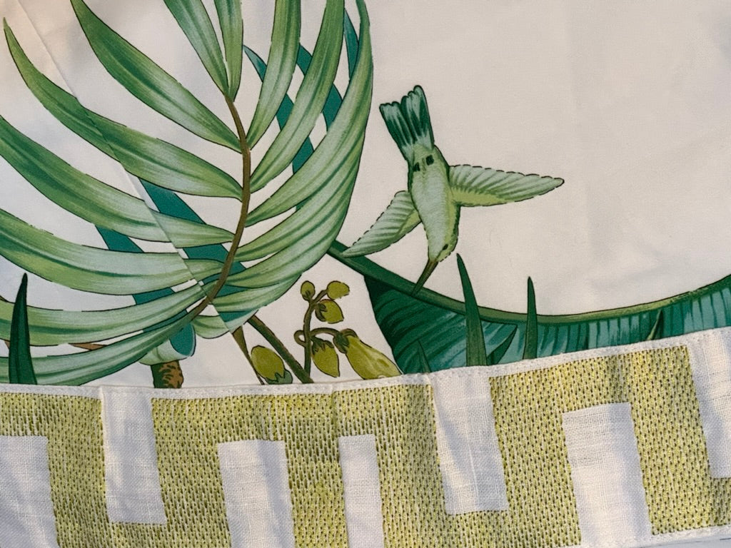 Brunschwig & Fils Anima tablecloth detail with palm frond, hummingbird and chartreuse block-pattern border