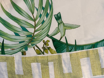 Brunschwig & Fils Anima tablecloth detail with palm frond, hummingbird and chartreuse block-pattern border
