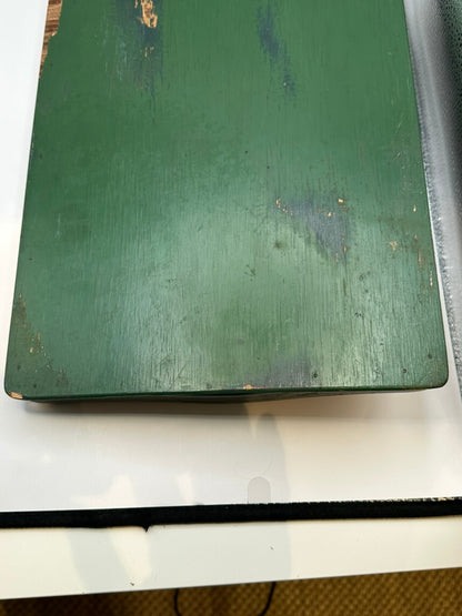 Underside of green wood tray, weathered green-painted surface with wear consistent with age