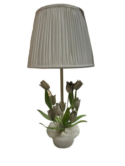 Vintage tole tulip and alabaster lamp with white pleated shade, shown in a showroom setting