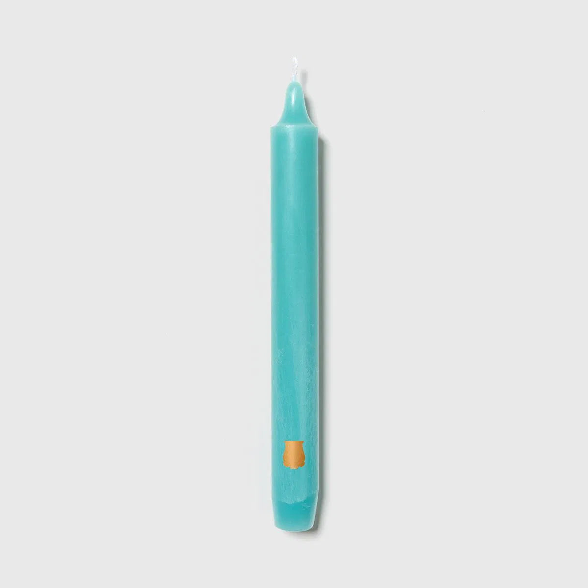 Single turquoise Trudon Madeleine taper candle with an embossed gold crest